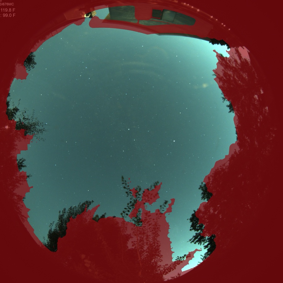 The automatic sky mask on a real clear-night frame: everything red — trees, rooflines, the mount of the camera itself — is excluded from cloud detection, leaving only true sky